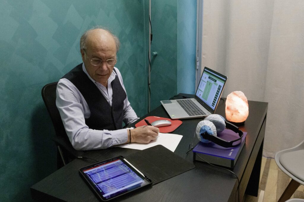 Mario Rotella al lavoro con computer e appunti in studio